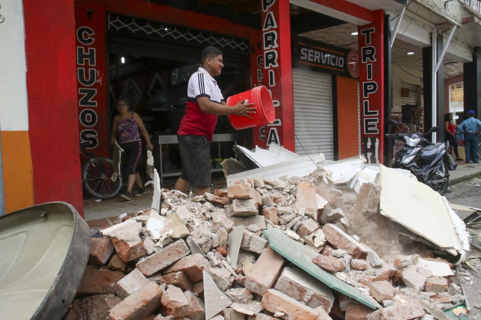 Un hombre retira escombros hoy, de una edificación afectada por un terremoto de magnitud 6,5 en la ciudad de Pasaje (Ecuador).