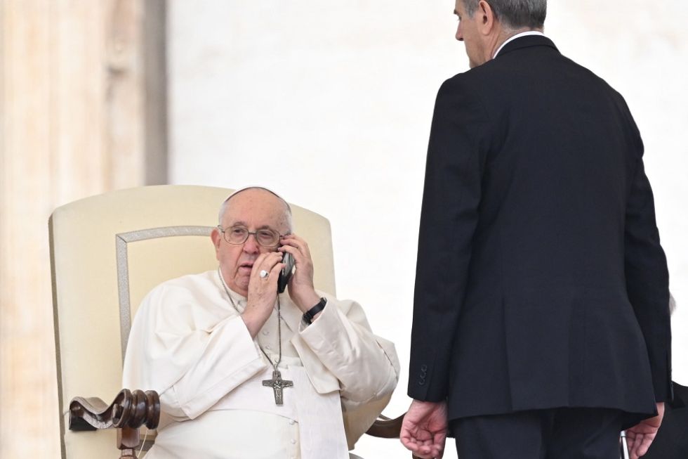 El Papa Francisco habla por teléfono durante su audiencia general del miércoles en la Plaza de San Pedro en el Vaticano.