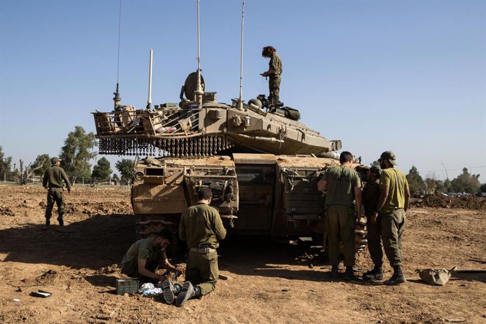 Soldados israelíes realizan trabajos de mantenimiento en tanques de batalla en la frontera con la Franja de Gaza.