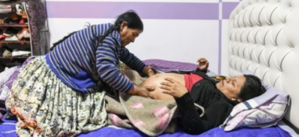 Ana, una partera tradicional indígena de origen aymara, masajea el vientre de Estefani (29), embarazada de ocho meses.