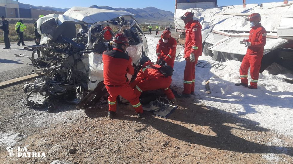 Bomberos intentan rescatar a pasajeros del minibús implicado en el accidente. 