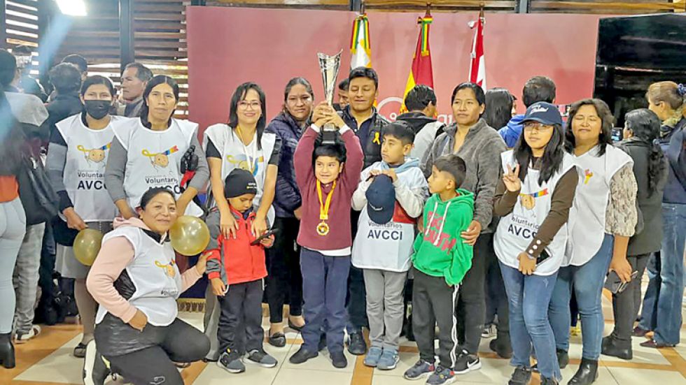 DISTINCIÓN. Áxel Fernando levanta el trofeo junto a voluntarios de la Avcci y autoridades municipales.