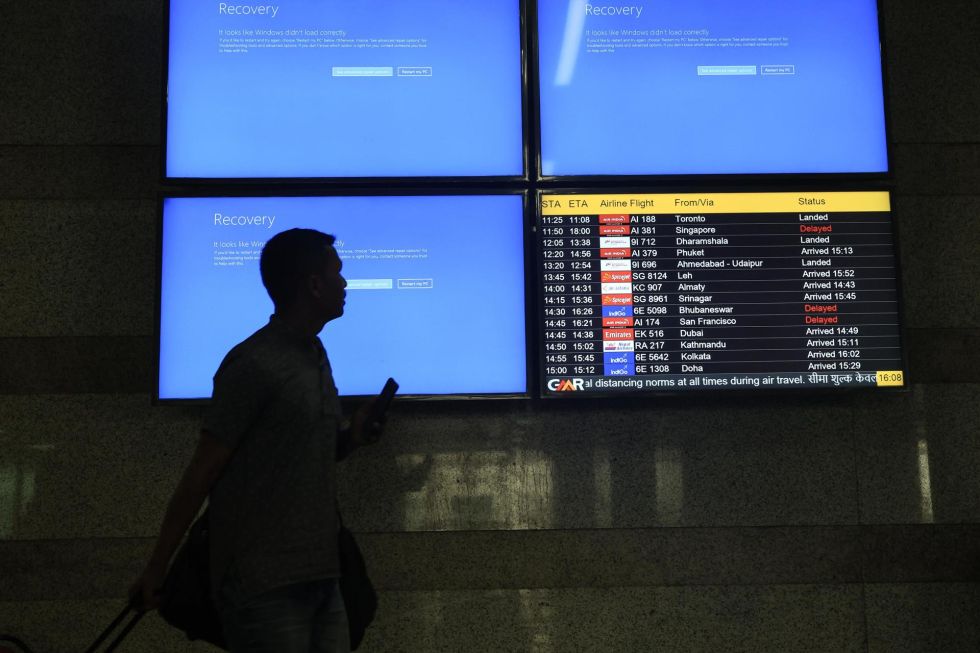 Un pasajero pasa por pantallas de información que no funcionan en el aeropuerto internacional de Delhi, en Nueva Delhi, India.