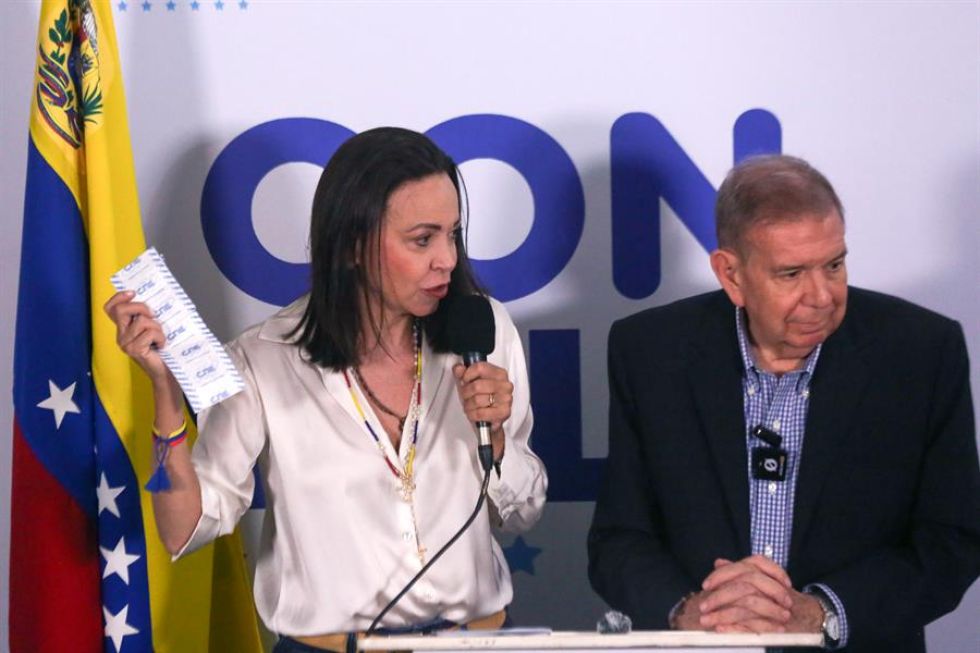 La líder opositora María Corina Machado (i) muestra un acta de las elecciones venezolanas.