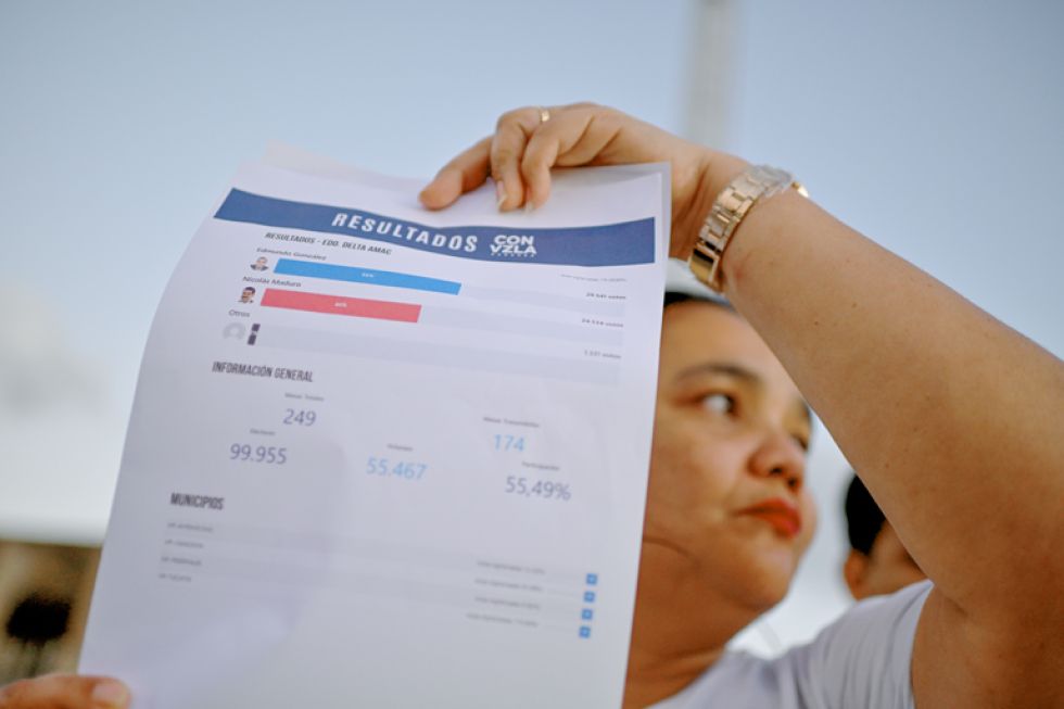 VENEZUELA. Una mujer protesta sosteniendo una hoja con los resultados tras las elecciones presidenciales del domingo.