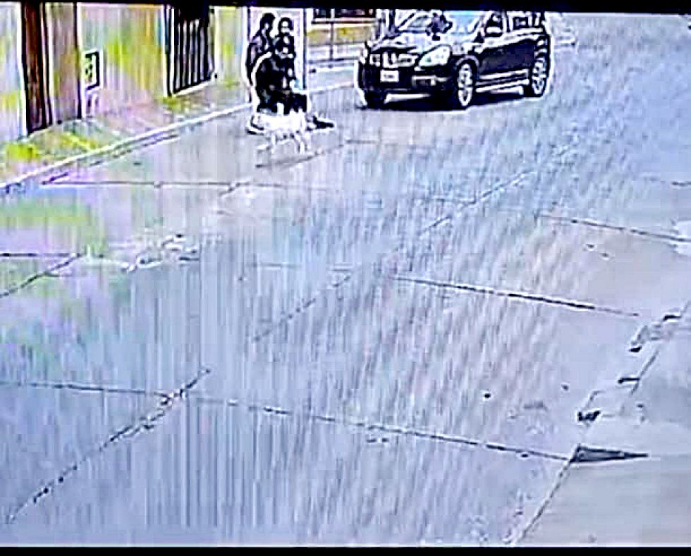 ACCIDENTE. El momento en que levantan a la persona herida para dejarla en la acera.