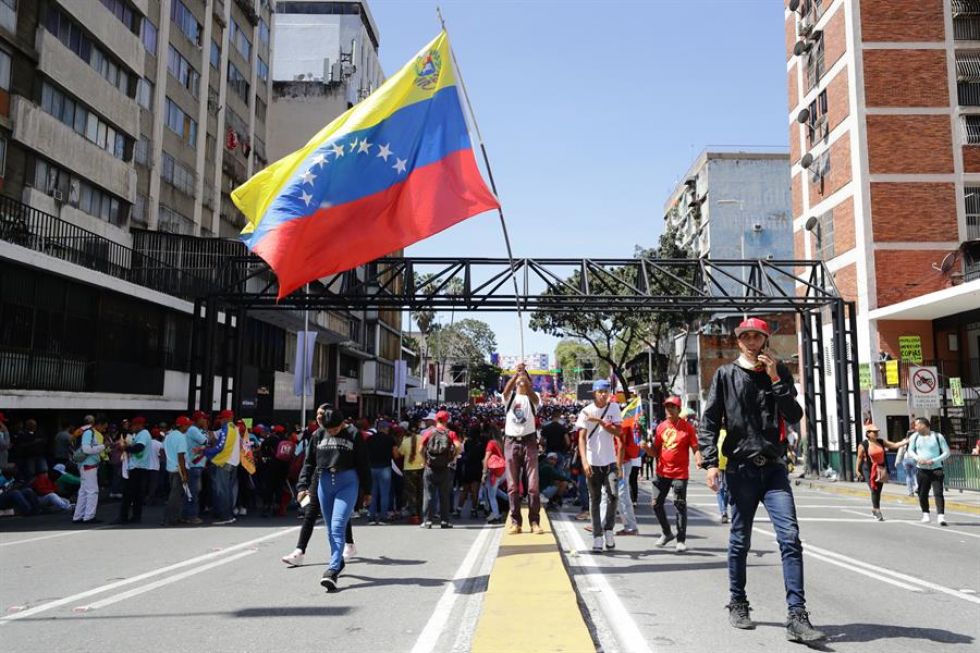 Seguidores del líder chavista Nicolás Maduro caminan por una calle este viernes en Caracas (Venezuela).
