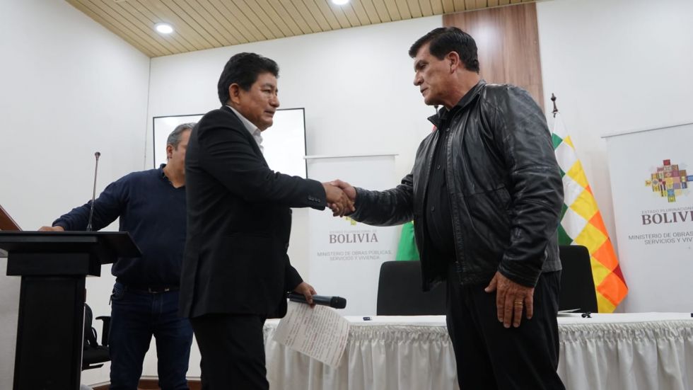 El ministro de Obras Públicas, Édgar Montaño (i), saluda al nuevo gerente de BoA, Ronald Casso.