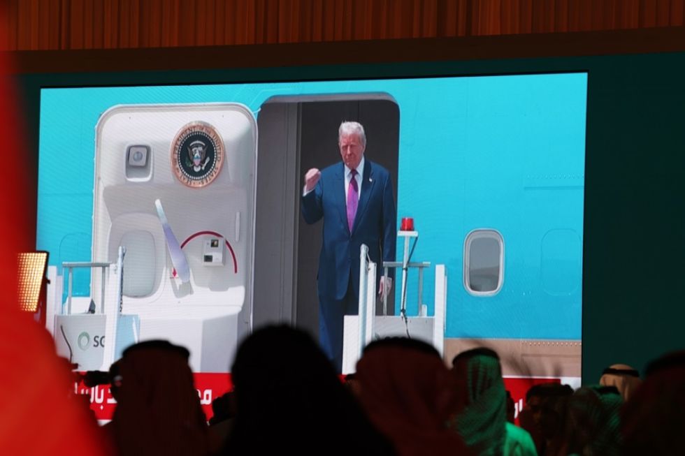 Una pantalla muestra al presidente estadounidense Donald Trump desembarcando del Air Force One tras aterrizar en Riad.