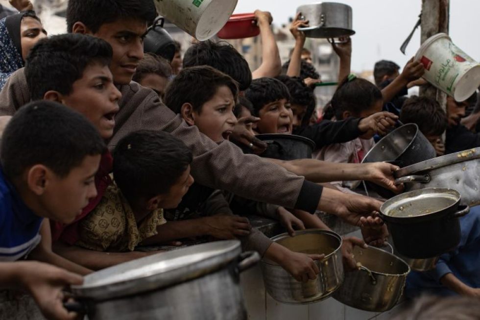 Imagen de 24 de abril de 2025 de refugiados palestinos esperando una ración de comida de ayuda humanitaria en Jabalia.