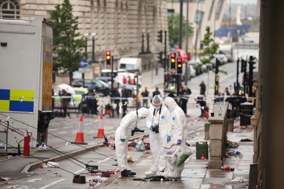 Agentes forenses en el lugar donde un coche colisionó con varias personas durante el desfile de la victoria del Liverpool FC.