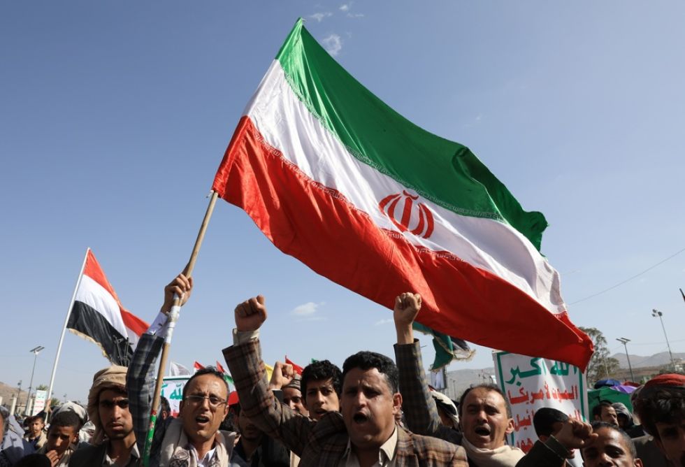 Simpatizantes hutíes gritan consignas y ondean banderas iraníes y yemeníes durante una protesta contra Estados Unidos y contra Israel.