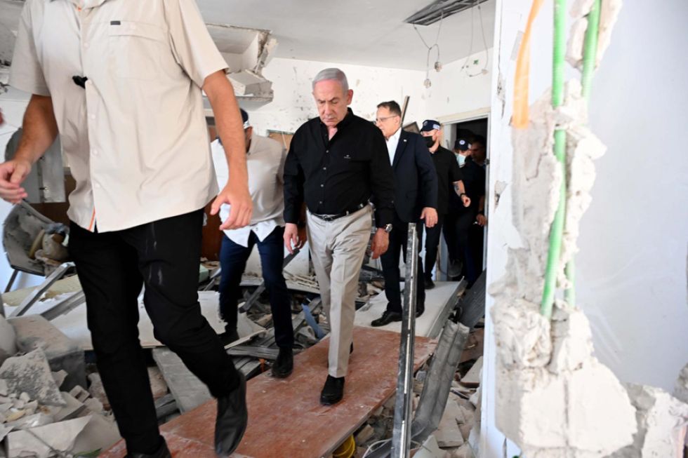 El primer ministro israelí, Benjamín Netanyahu (c), visita este domingo el lugar en el que impactó un misil balístico iraní.