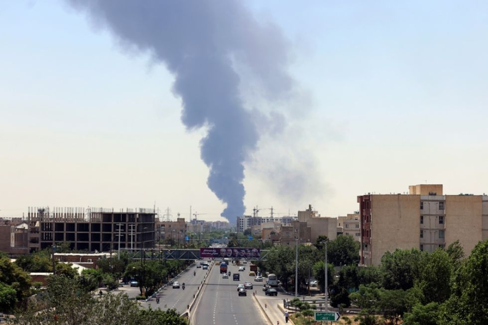 El humo de una refinería de petróleo se eleva sobre edificios residenciales en el sur de Teherán, Irán.
