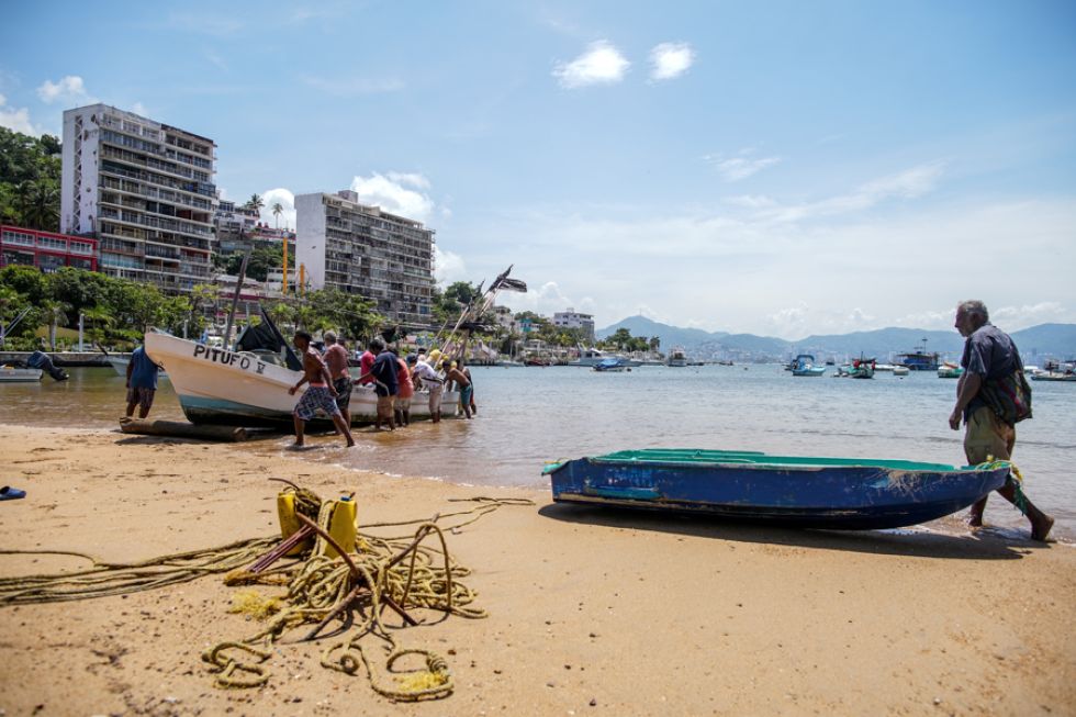 Pescadores trasladan una embarcación previo a la llegada del huracán Erick, en Acapulco (México).