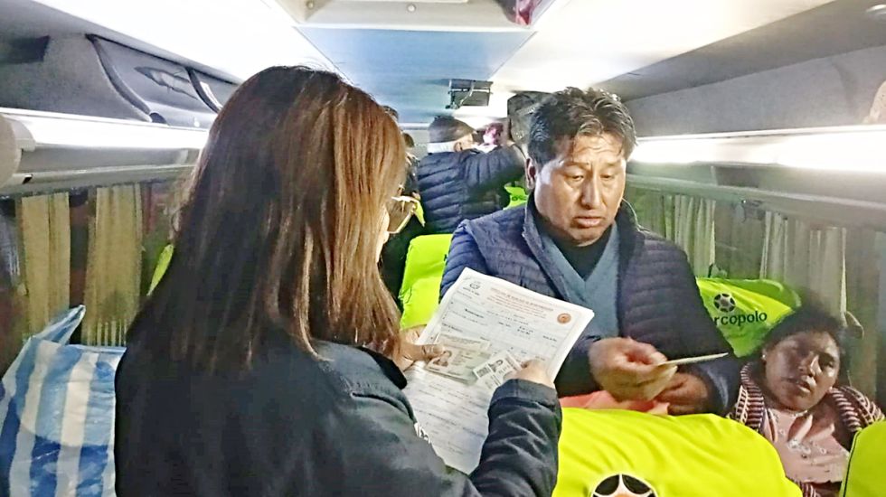 OPERATIVO. Una funcionaria revisa el permiso de viaje de un menor de edad, el fin de semana.