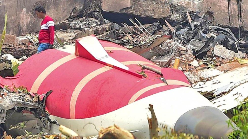TRAGEDIA. Trabajadores retiraban los restos del avión cerca del aeropuerto de Ahmedabad en junio.