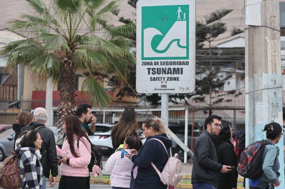 Personas permanecen en un área segura después de evacuar de la zona costera este miércoles, en Iquique (Chile).