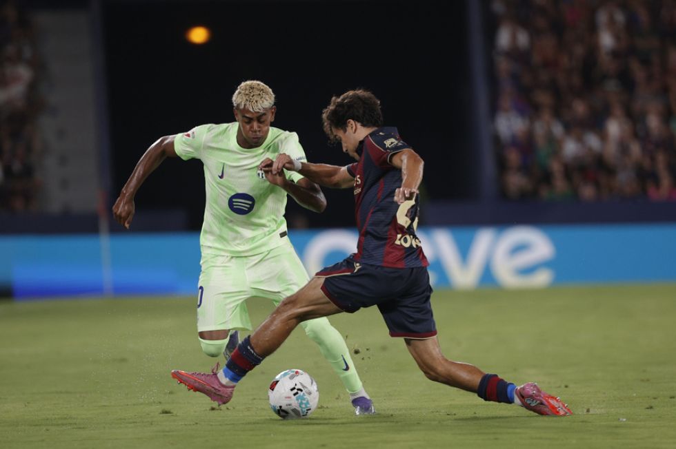 El defensa del Levante Manu Sánchez (d) pelea un balón con el delantero del Barcelona Lamine Yamal.