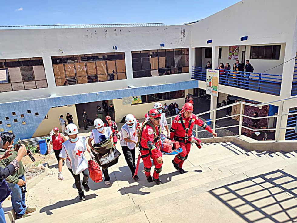ATENCIÓN. Bomberos y personal de Cruz Roja evacuan a un herido en el simulacro de ayer.