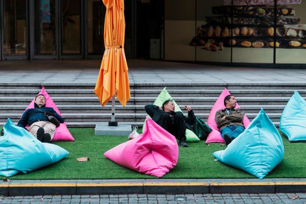 Repartidores descansan frente a un centro comercial en Shanghái (China). 
