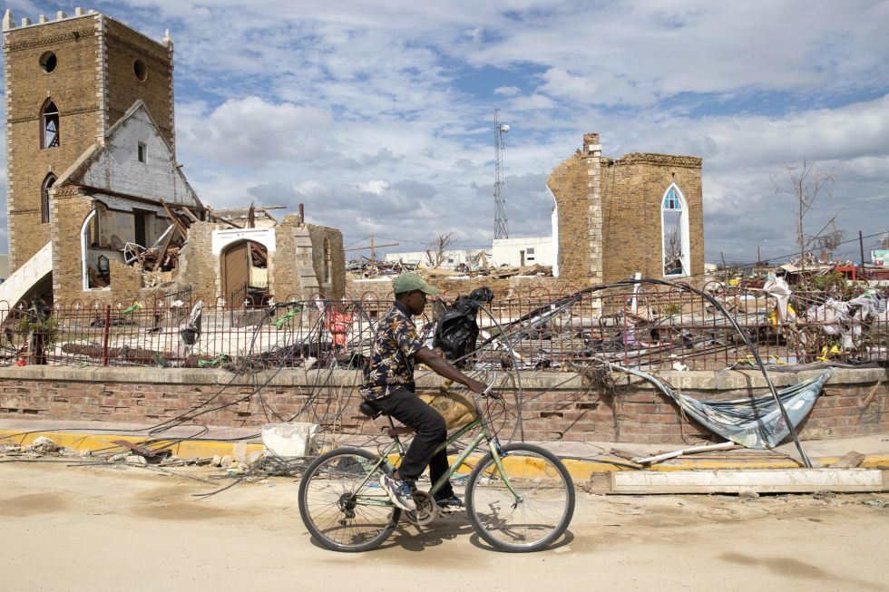 Un hombre recorre en bicicleta frente a escombros de una catedral causados por el huracán Melissa este martes, en Black River (Jamaica).