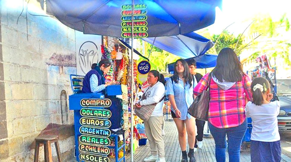 MERCADO PARALELO. Una librecambista atiende a una cliente en Cochabamba.